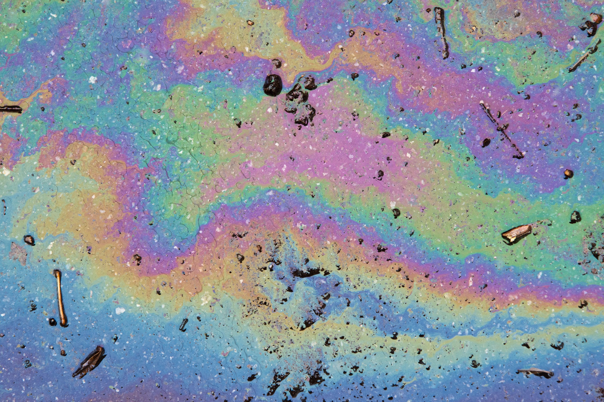 Picture of an oil spill on asphalt. Rainbow colors.